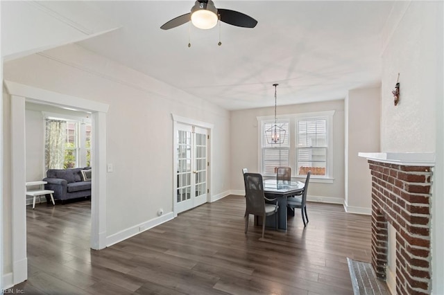 dining area featuring dark wood-style flooring, plenty of natural light, baseboards, and ceiling fan with notable chandelier