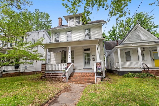 traditional style home featuring a chimney, a porch, and a front yard