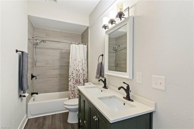 full bath featuring double vanity, wood finished floors, toilet, and a sink