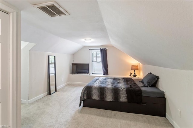 carpeted bedroom featuring visible vents, vaulted ceiling, and baseboards