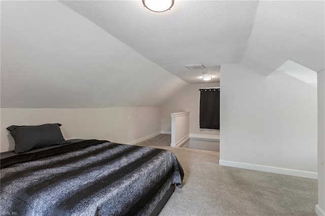bedroom with visible vents, vaulted ceiling, baseboards, a textured ceiling, and carpet floors