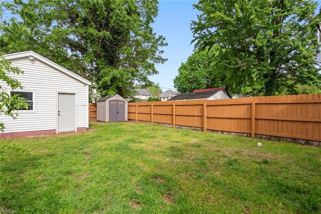 view of yard with an outbuilding, a shed, and a fenced backyard