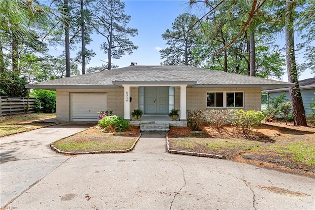 ranch-style house featuring driveway, a garage, fence, and brick siding