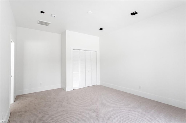 unfurnished room featuring visible vents, light carpet, and baseboards
