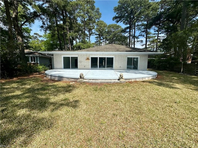 rear view of property with a patio, brick siding, and a lawn