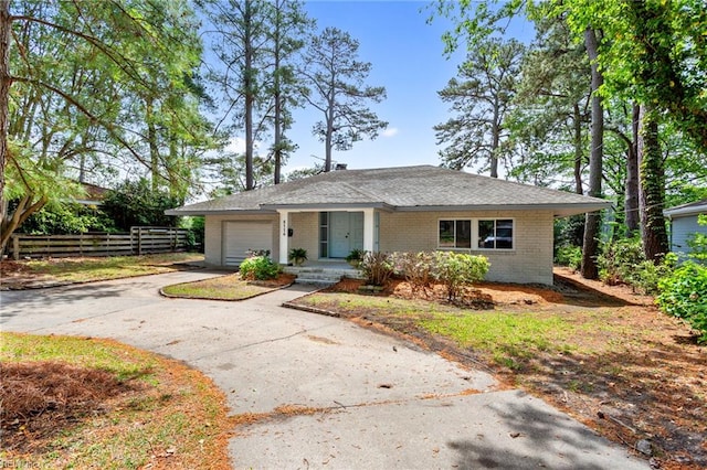 view of front of property with aphalt driveway, covered porch, fence, brick siding, and a garage