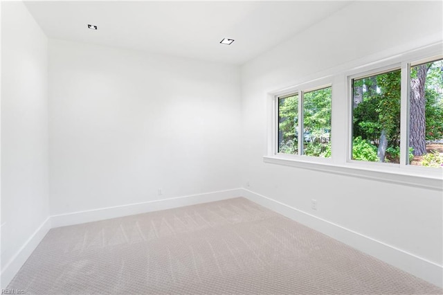 unfurnished room with light carpet and baseboards