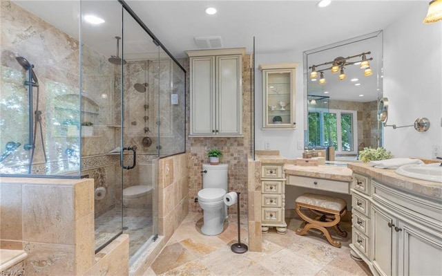full bath with tile walls, a stall shower, vanity, toilet, and recessed lighting