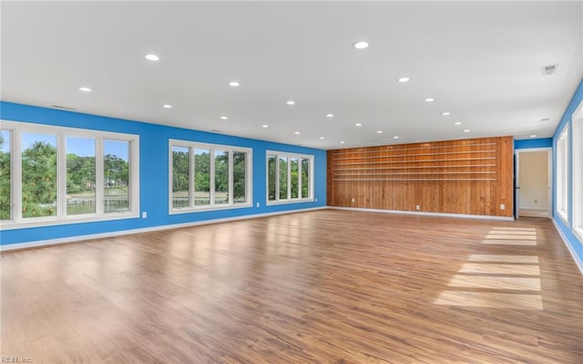 unfurnished living room with recessed lighting, light wood-style flooring, baseboards, and visible vents