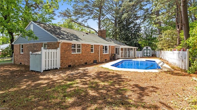 view of swimming pool with central air condition unit, an outbuilding, a fenced in pool, a storage unit, and fence