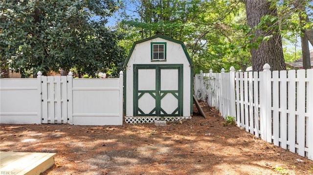 view of shed with a fenced backyard and a gate