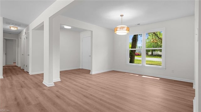 unfurnished dining area featuring visible vents, light wood finished floors, and baseboards