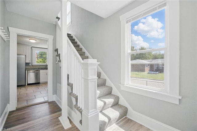 stairs featuring wood finished floors and baseboards