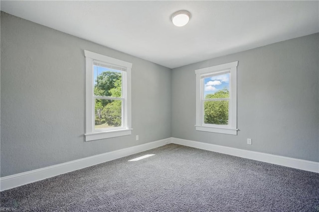 carpeted empty room featuring baseboards