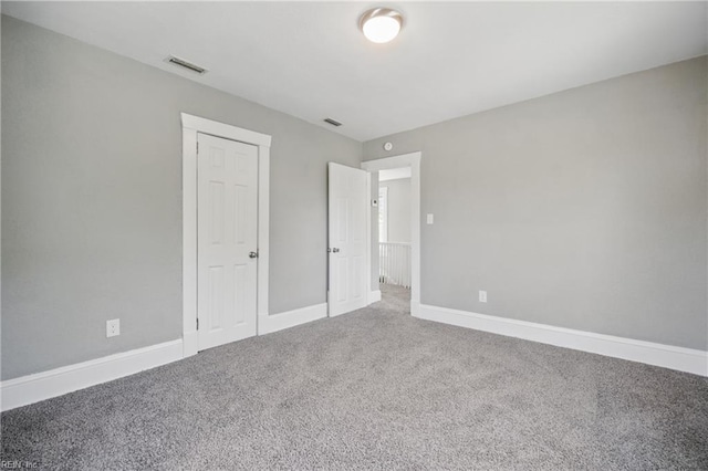 unfurnished bedroom with carpet, visible vents, and baseboards