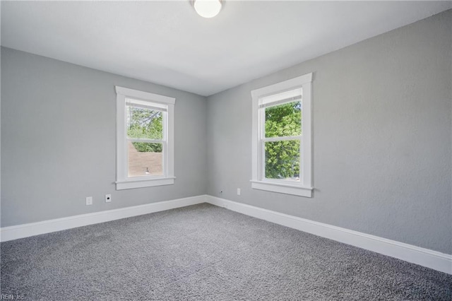 carpeted spare room featuring baseboards