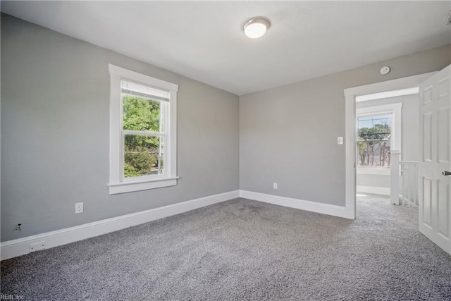 carpeted spare room featuring baseboards