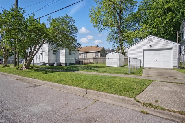 view of yard with a garage, an outdoor structure, a residential view, driveway, and fence