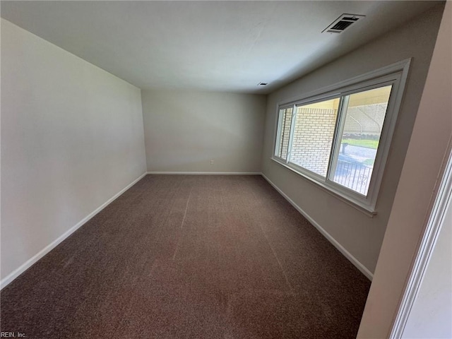 empty room featuring baseboards, visible vents, and carpet flooring