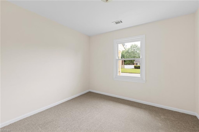 spare room featuring visible vents, baseboards, and light carpet