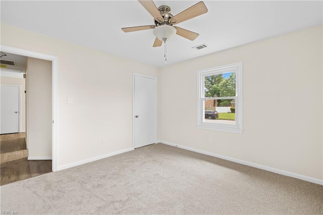 spare room featuring visible vents, baseboards, a ceiling fan, and carpet floors