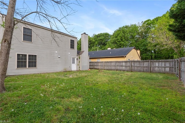 rear view of property with a lawn and a fenced backyard