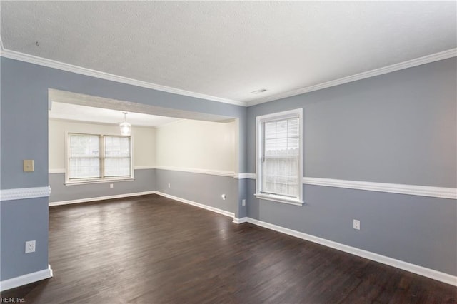 empty room featuring baseboards, wood finished floors, a textured ceiling, and ornamental molding