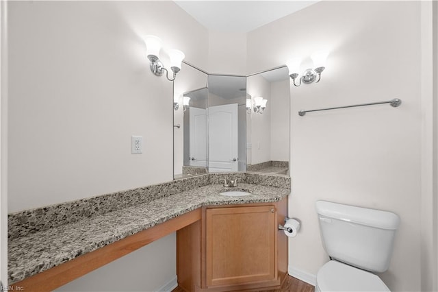 half bath with vanity, toilet, and wood finished floors