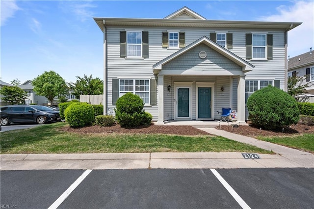 view of property featuring uncovered parking and covered porch