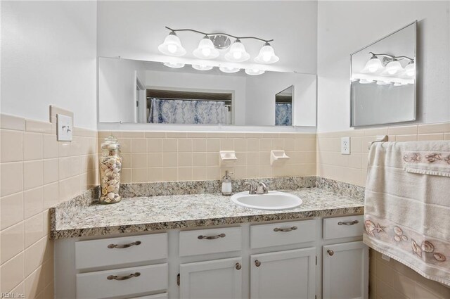 full bathroom featuring tile walls and vanity