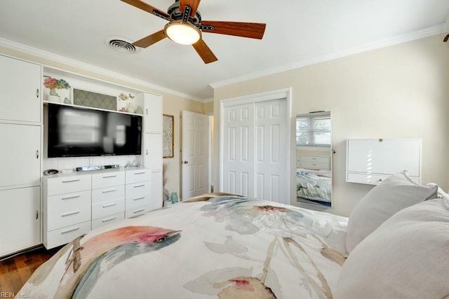 bedroom featuring crown molding, visible vents, ceiling fan, a closet, and dark wood finished floors