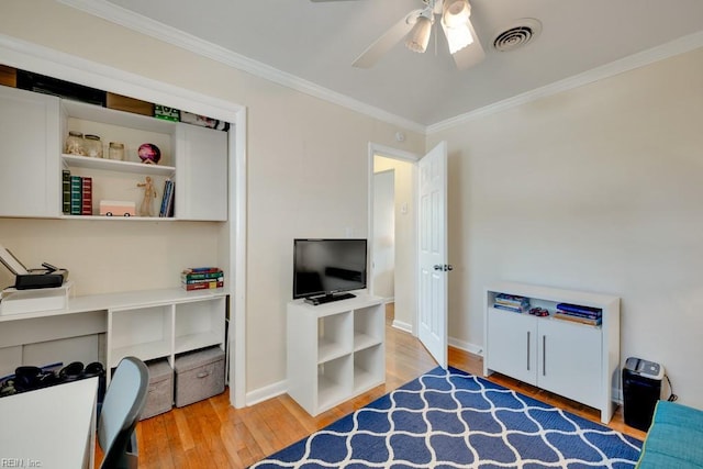 bedroom with a ceiling fan, visible vents, baseboards, ornamental molding, and hardwood / wood-style flooring