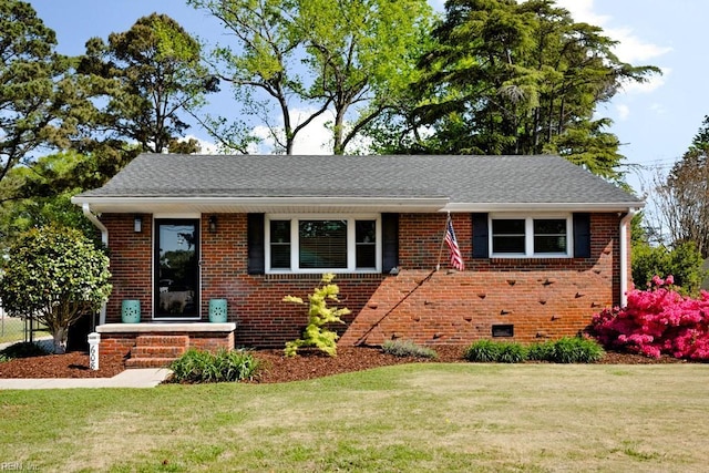 view of front facade with a front lawn, a shingled roof, and brick siding