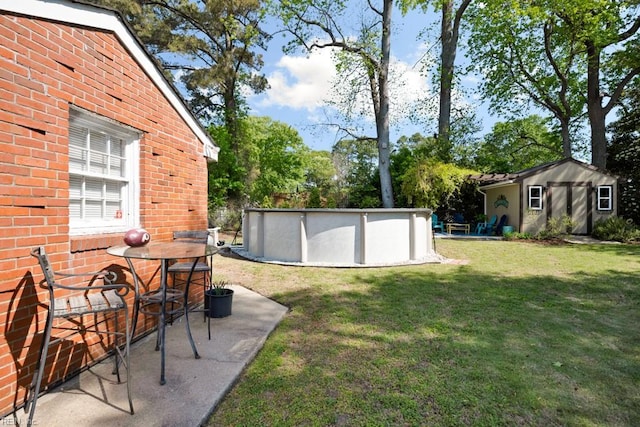 view of yard with a patio area, an outbuilding, and an outdoor pool