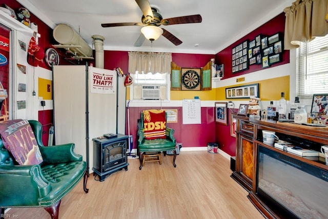 interior space with cooling unit, wood finished floors, ceiling fan, and ornamental molding