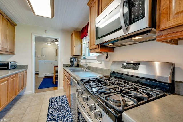 kitchen with a baseboard heating unit, a sink, stainless steel appliances, light countertops, and a toaster