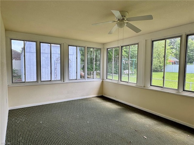 unfurnished sunroom with baseboards and a wealth of natural light