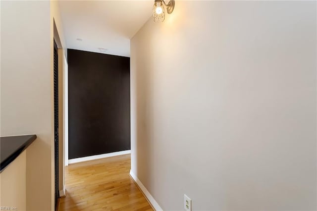 hall featuring baseboards and light wood-style floors