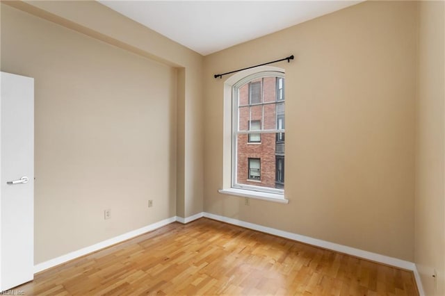 empty room featuring baseboards and light wood-style floors