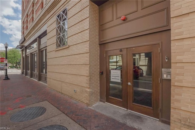 property entrance featuring brick siding and french doors