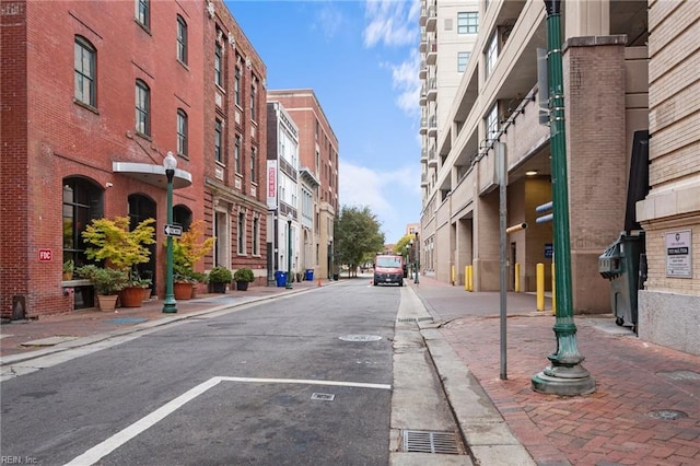 view of street featuring curbs, sidewalks, a residential view, and street lighting