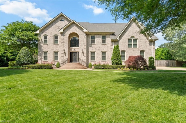 view of front facade featuring brick siding and a front yard