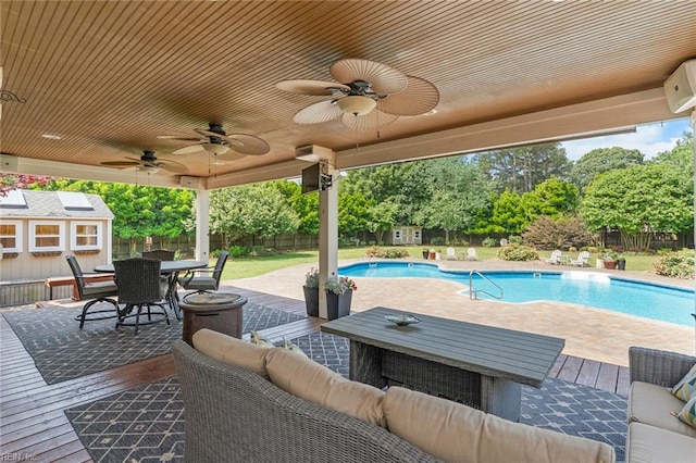 view of patio featuring a ceiling fan, outdoor dining area, a fenced in pool, an outdoor structure, and a fenced backyard