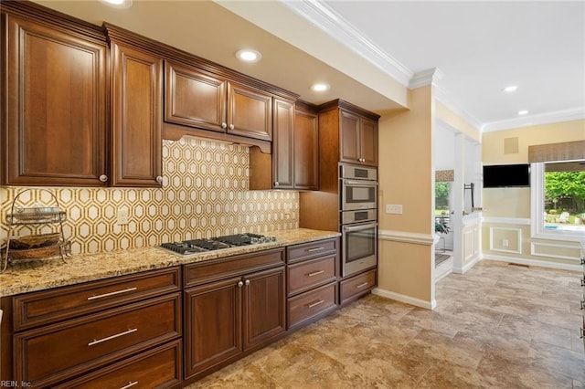 kitchen featuring crown molding, decorative backsplash, baseboards, light stone counters, and stainless steel appliances