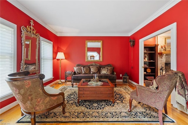 living room with crown molding, baseboards, and wood finished floors