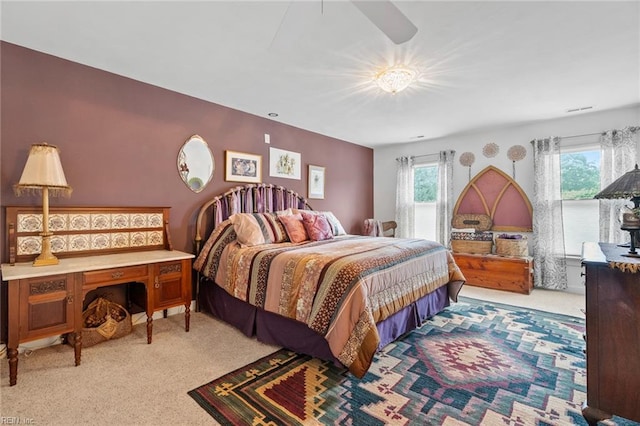 carpeted bedroom with a ceiling fan and multiple windows