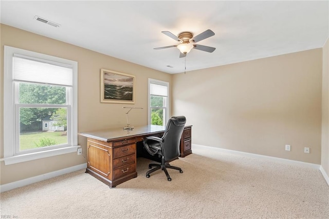 home office featuring visible vents, a ceiling fan, baseboards, and light carpet