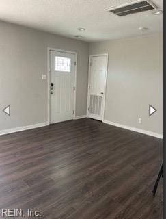foyer with visible vents, dark wood finished floors, and baseboards