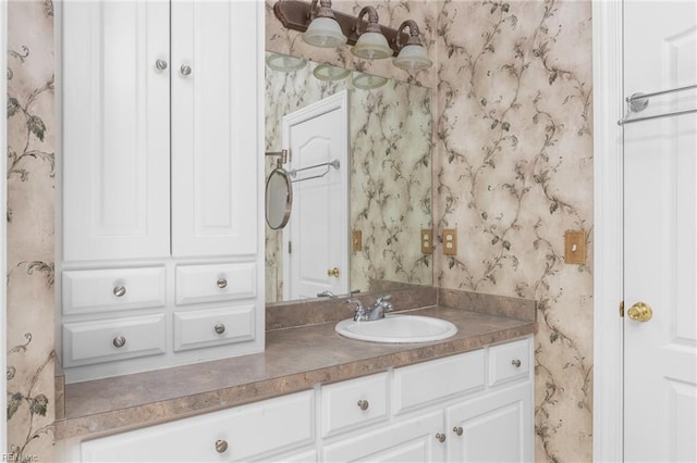 bathroom featuring vanity and wallpapered walls