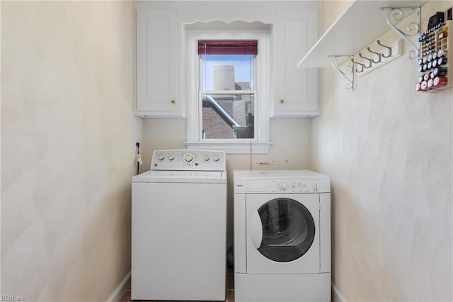laundry area with cabinet space, baseboards, and washer and clothes dryer